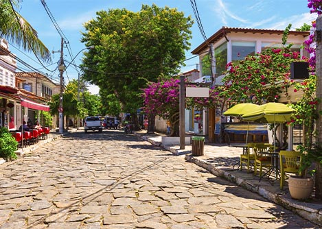A cobbled street lined with cute shops and lots of greenery in the historic center of Buzios.