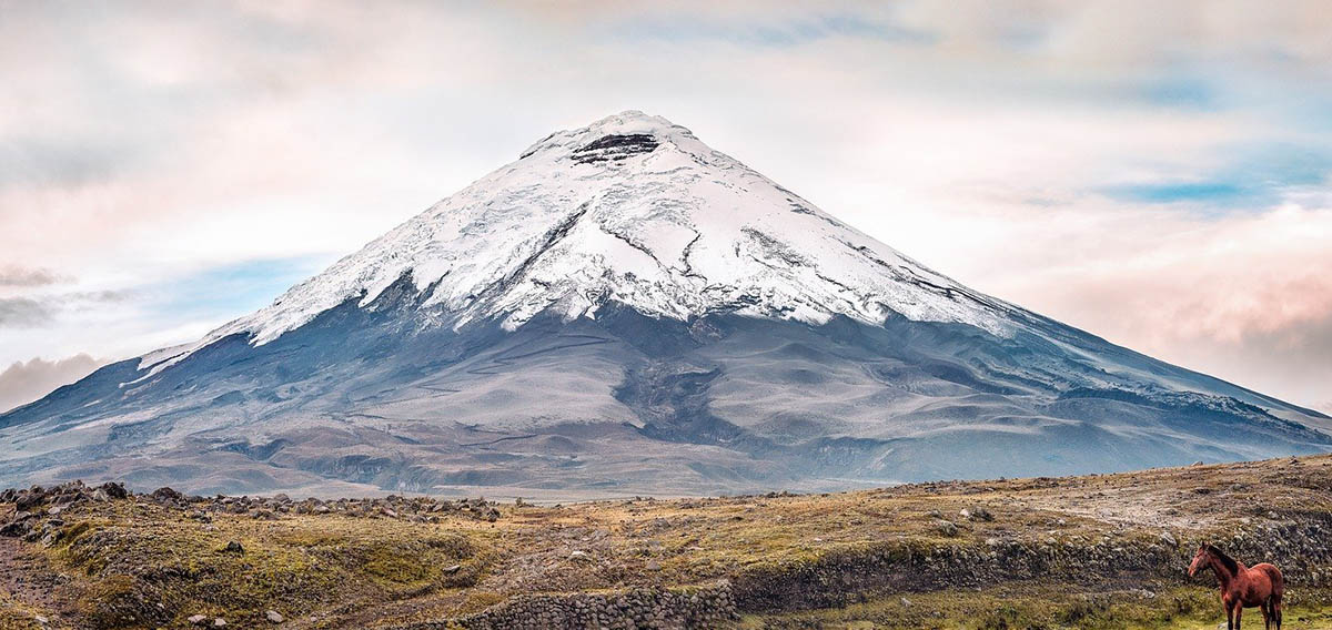A tall, snow-capped volcano known as Cotopaxi, one of the best places to visit in Ecuador.