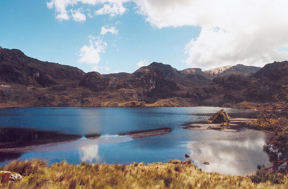 A shallow blue lagoon surrounded by brown rocky terrain in the El Cajas National Park.