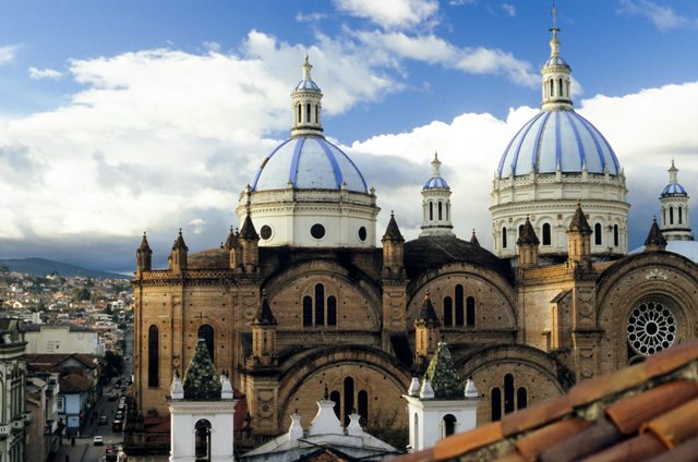 The pink façade and blue domes of the new Cuenca cathedral, known as La Catedral, is one of the iconic sites of Cuenca travel. The cathedral is located on Parque Calderon, the social and historical heart of the city.