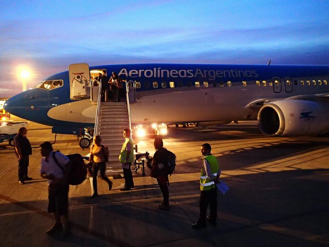 An Aerolineas Argentinas plane with guests disembarking on a staircase.