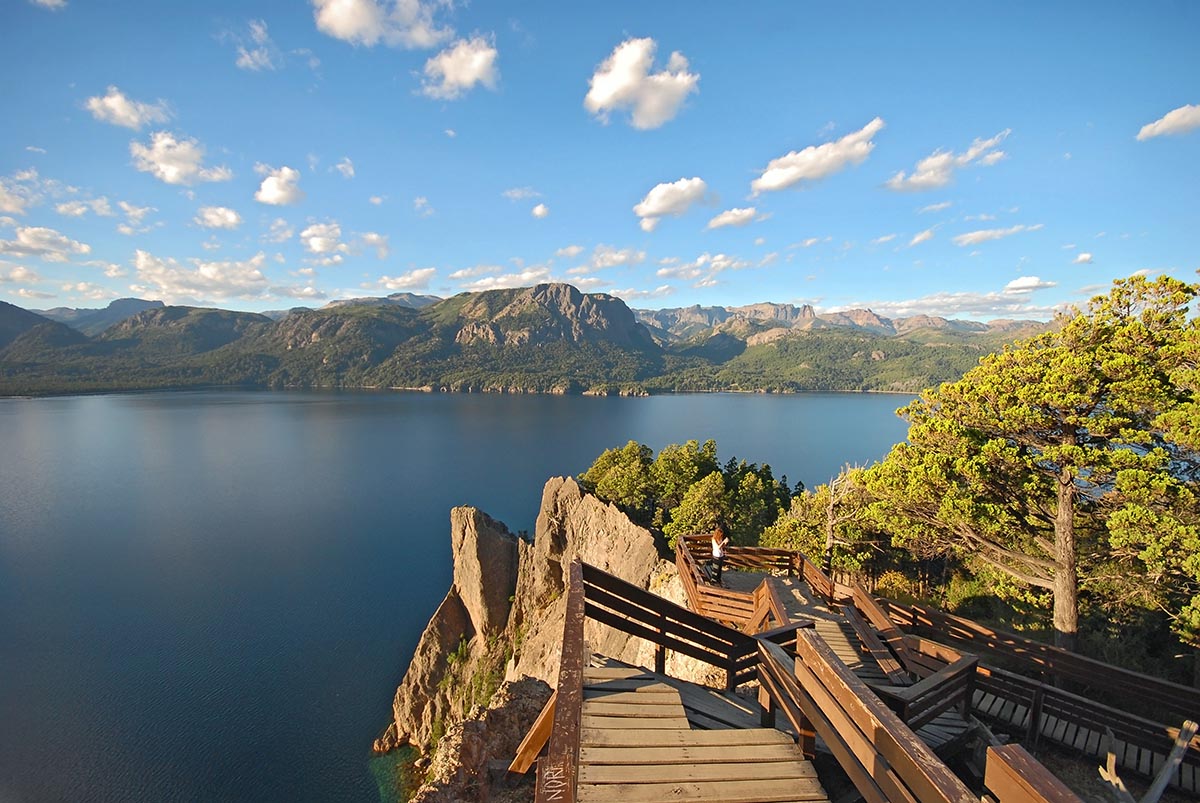 A deep blue lake with a wooden hiking path along the shore in the Nahuel Huapi National Park.