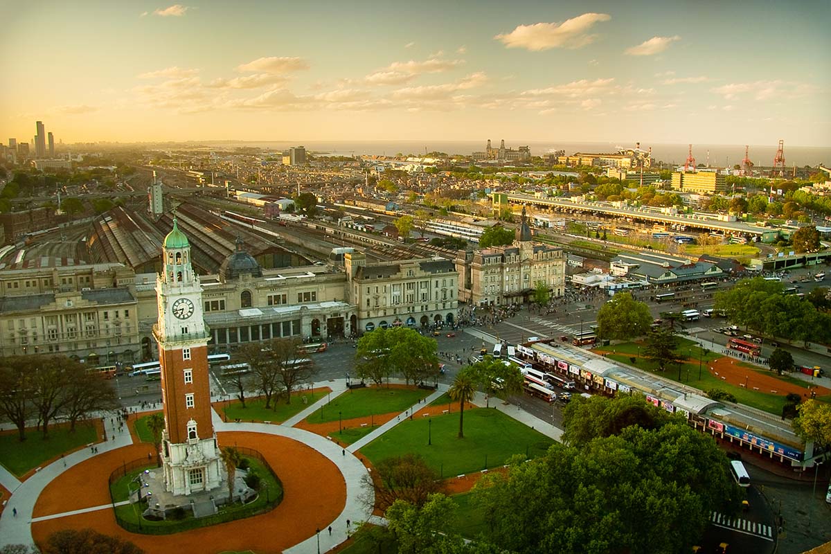 A tall orange and white tower in the middle of a square in Buenos Aires, Argentina.