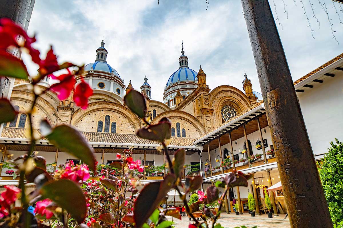 The courtyard of Cuenca's New Cathedral with two sky blue domes sitting on top.
