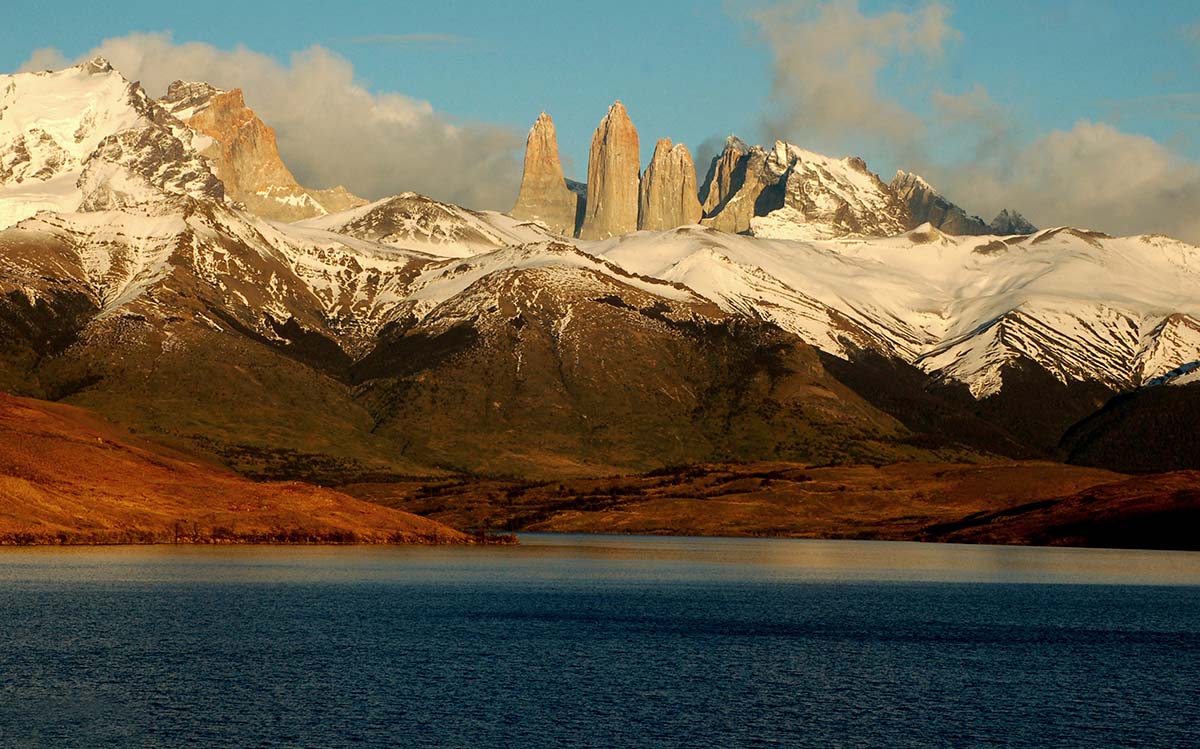 Granite spires, snow covered mountains, and a deep blue lake in the Torres del Paine National Park.