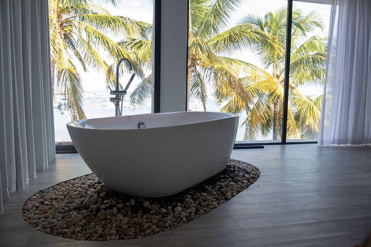 Stand-alone bath with floor to ceiling windows overlooking the sea at Golden Bay Galapagos Hotel.