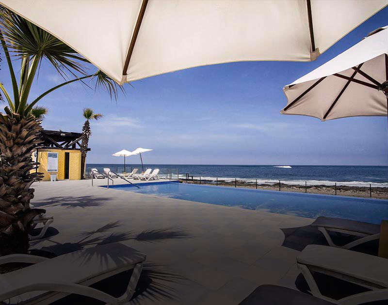 Beach chairs next to a pool overlooking the ocean at the Panamericana Hotel in Arica.