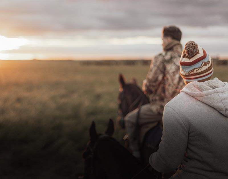 A rider on horseback wearing a hat with another rider in a field near Buenos Aires.