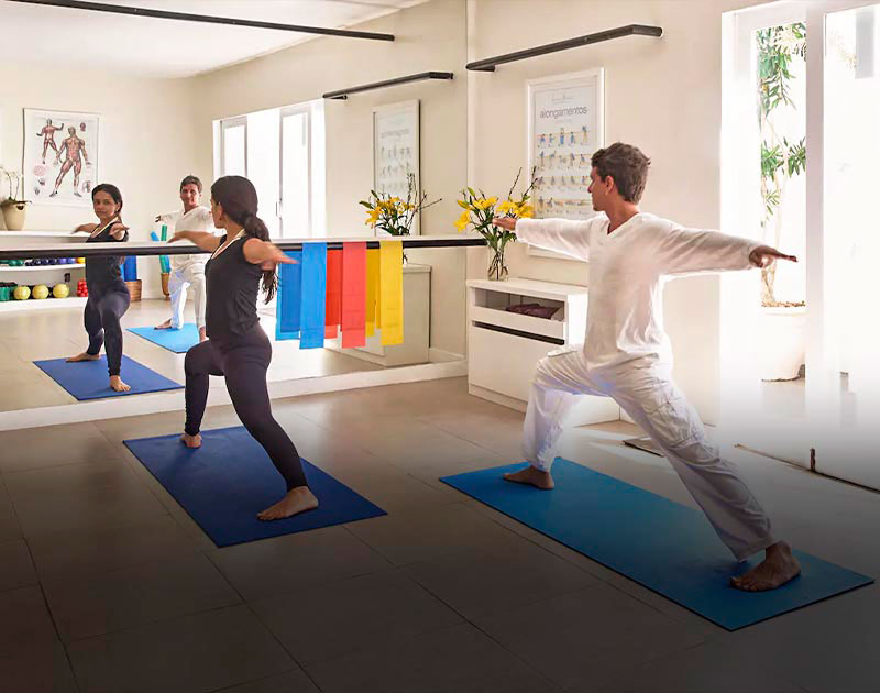 A man and a woman doing stretching exercises at Casa Brancas Boutique Hotel in Buzios.