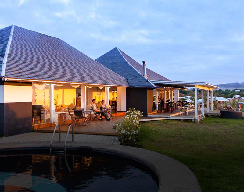 Visitors relaxing on a patio next to a pool at the Hotel Altiplanico Rapa Nui on Easter Island.