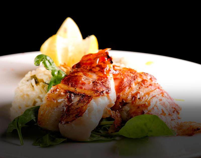 A plate with risotto and fish fillets breaded in herbs and spices at a restaurant on Easter Island.