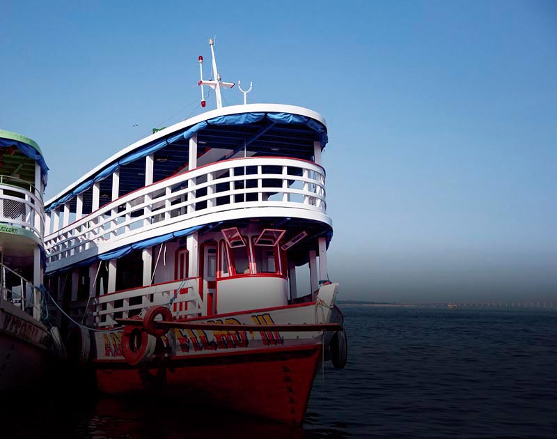 Two cruise ships, each with two decks, tied to one another on the Amazon River near Manaus.