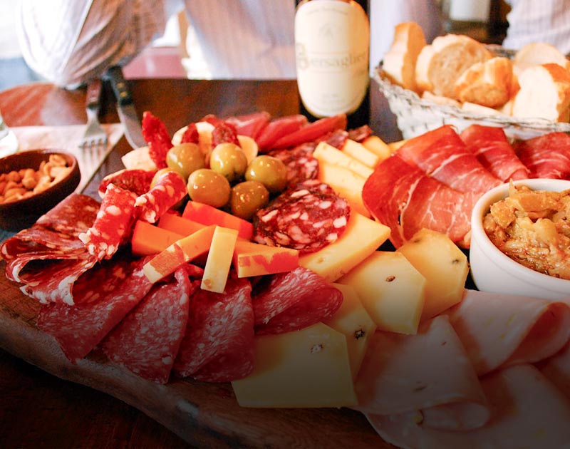 A charcuterie plate featuring a variety of different meats and cheeses at a restaurant in Mendoza.