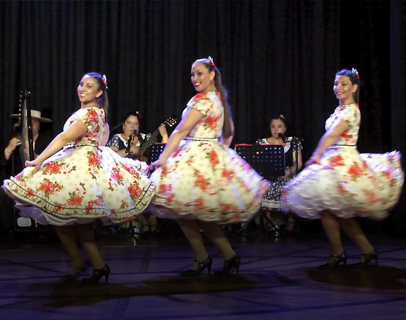 Three dancers performing the cueca, a traditional Chilean dance, at an event in Puerto Montt.