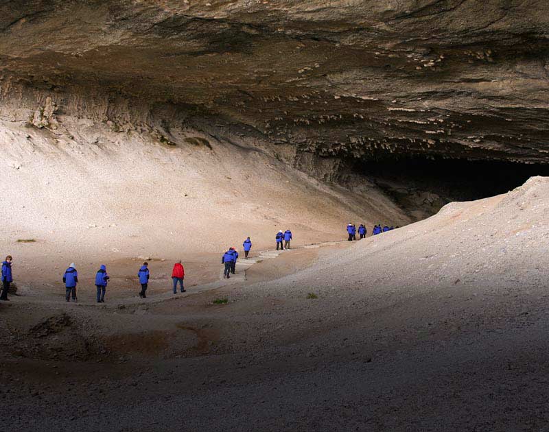 A group of tourists entering Mylodon Cave, a popular attraction near Puerto Natales.