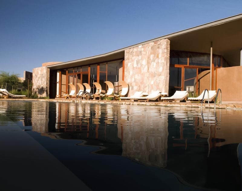 Beach chairs around a large pool at the Tierra Atacama Hotel in San Pedro de Atacama.