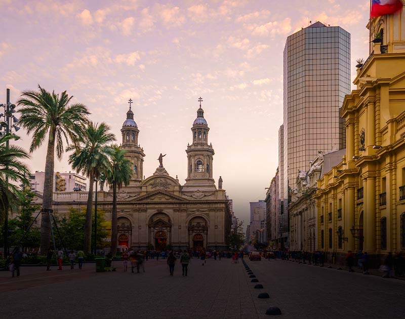 Visitors in the main square of Santiago, surrounded by both historic and modern buildings.