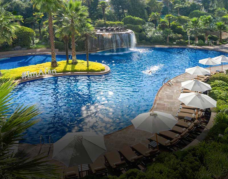 Chairs lining a large pool with an artificial waterfall at the Mandarin Oriental Hotel in Santiago.
