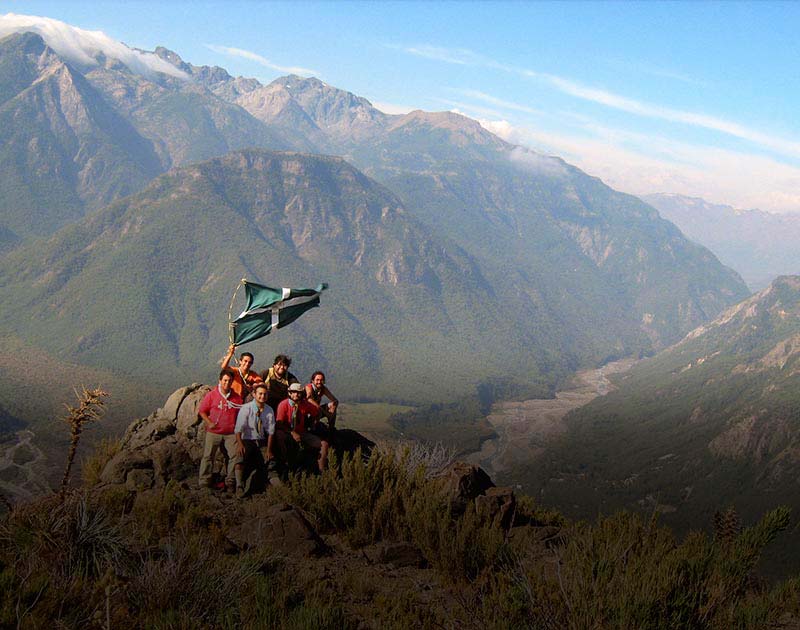 Several hikers posing with a flag at a lookout point on Cerro La Campana in northern Chile.