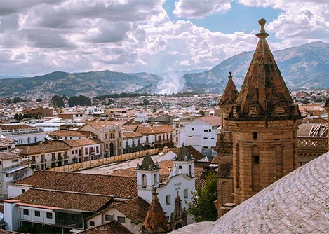 A view of the city of Cuenca on a cloudy day as seen from the roof of a cathedral.