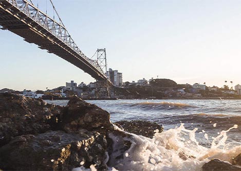 Waves splashing up onto some rocks underneath the Hercílio Luz Bridge in Florianopolis.