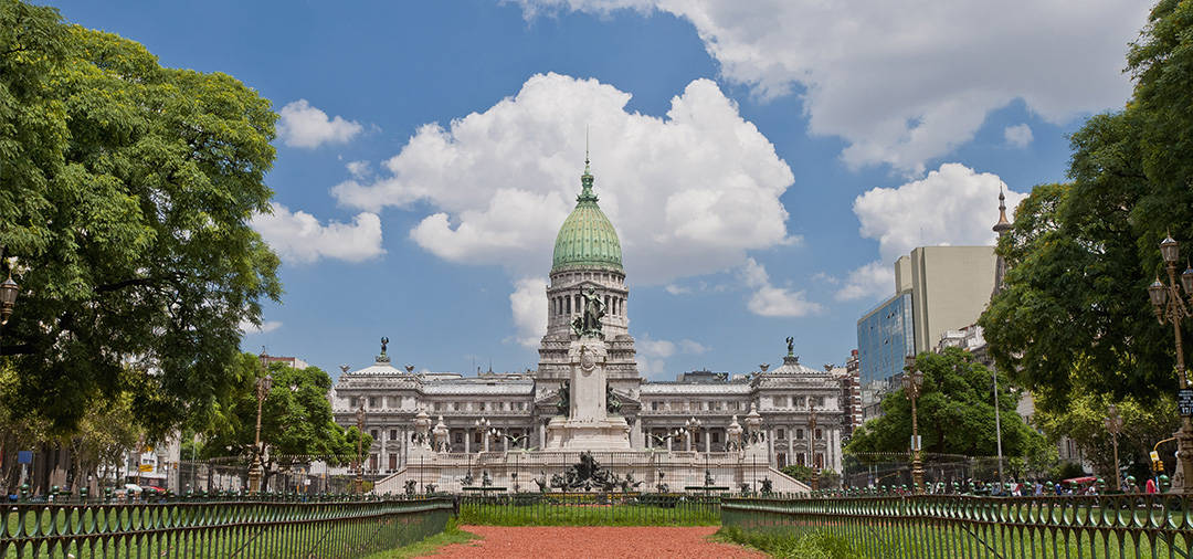 The Palace of the Argentine National Congress overlooking a statue and small park.