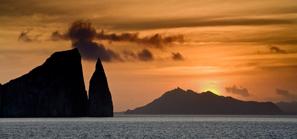 The sun setting over the ocean and some rock formations at San Bartolome in the Galapagos.