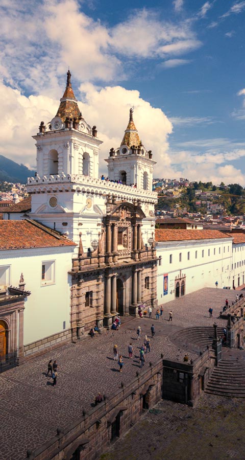 Visitors walking through the plaza next to the beautiful San Francisco cathedral in Cuenca.