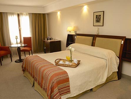 A lovely and spacious room at the Hotel Almeria, with a tray of breakfast laid out on the bed.