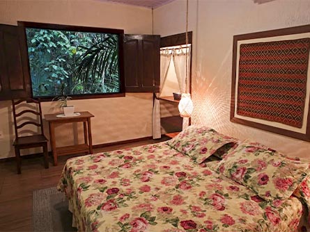 A cozy room with a window facing out into lush rainforest greenery at the Amazon Ecopark Lodge.