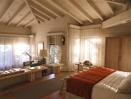 A room at Awasi Iguazu, surrounded by the rainforest which is visible through the windows.