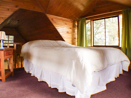 A cozy room with cabin-style wood walls and ceiling at the Cabañas del Lago hotel in Puerto Varas.