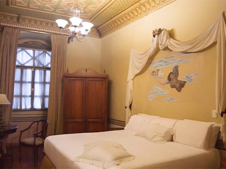 A classic room with an angel design on the wall at the colonial Carvallo Hotel in Cuenca.