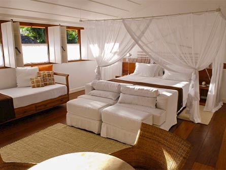 A beautiful room with a large bed surrounded by curtains at the Casa Turquesa in Paraty.