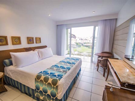 A cozy room with a view of a garden area outside at the Costão do Santinho Resort Vilas.