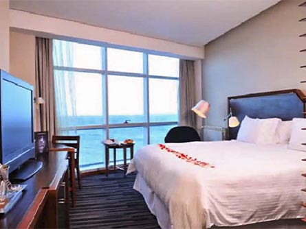 A cozy room at the Dreams Del Estrecho Hotel with a window looking directly out at the ocean.