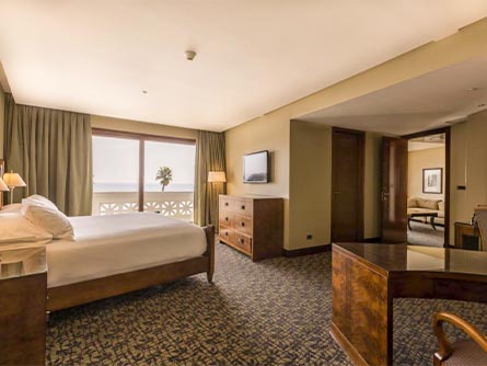 A spacious, carpeted room with a view of the ocean at the Enjoy Viña del Mar Hotel.