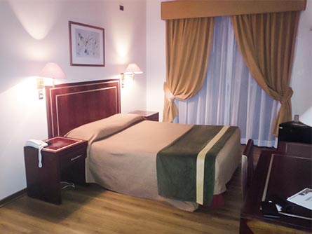 A cozy room featuring earth tones and a wood floor at the Francisco de Aguirre Hotel in La Serena.