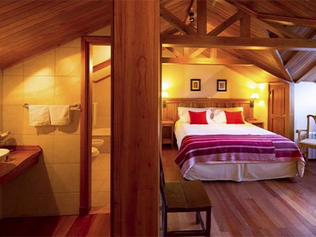 A cozy room featuring wood flooring and a cabin-style ceiling at Hosteria Senderos in El Chalten.