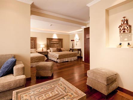 A spacious suite with a bedroom and living room area at the Ikala Quito luxury boutique hotel.