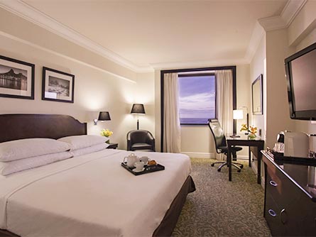 An elegantly-decorated room with carpeting and a large bed at the JW Marriott in Rio de Janeiro.