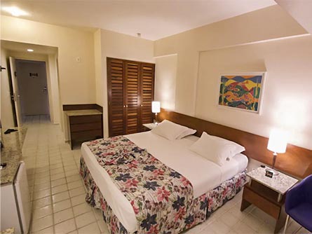 A cozy room with tile flooring and a large bed at the Kastel Manibu Hotel in Recife.