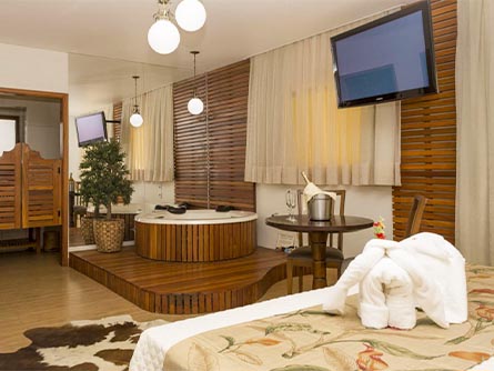 An elegant room with wooden saloon doors, wooden shades and a wooden hot tub at the Marrua Hotel.