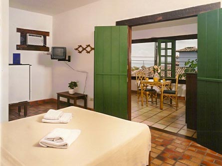 A cozy room with a folding wood doorway leading to a dining room area at the Pousada Barla Inn.