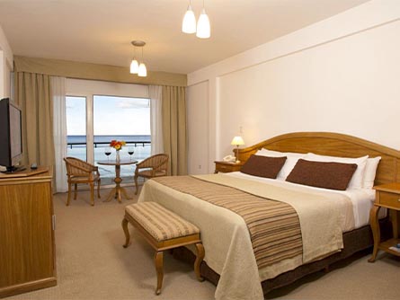 A room at the Villa Piren Hotel in Puerto Madryn with wine glasses on the table facing the ocean.