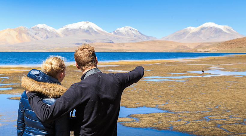 A couple visiting Laguna Chaxa, one of the many scenic lagoons near Chile's San Pedro de Atacama.