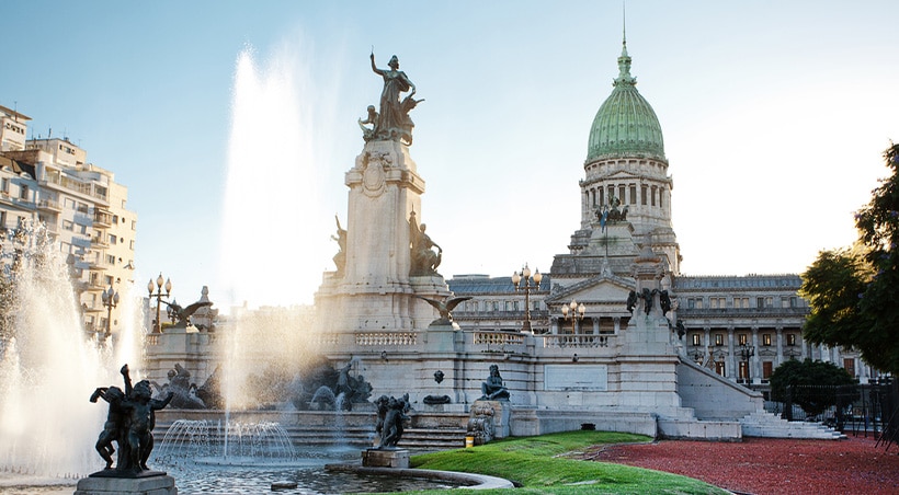 A water fountain and statues in front of the Palace of the Argentine National Congress.