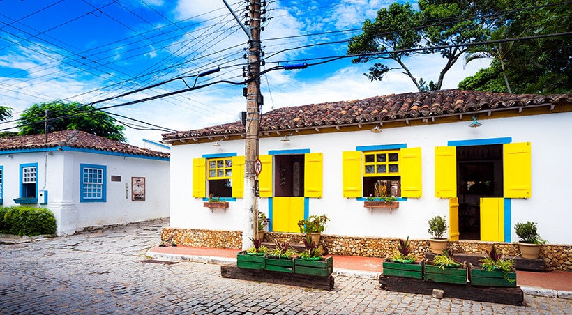 Houses with bright blue and yellow window frames in Búzios, a popular resort town in Brazil.
