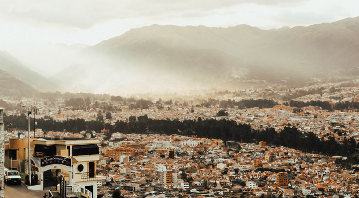 A panoramic view of the city of Cuenca and the surrounding mountains from a lookout point.