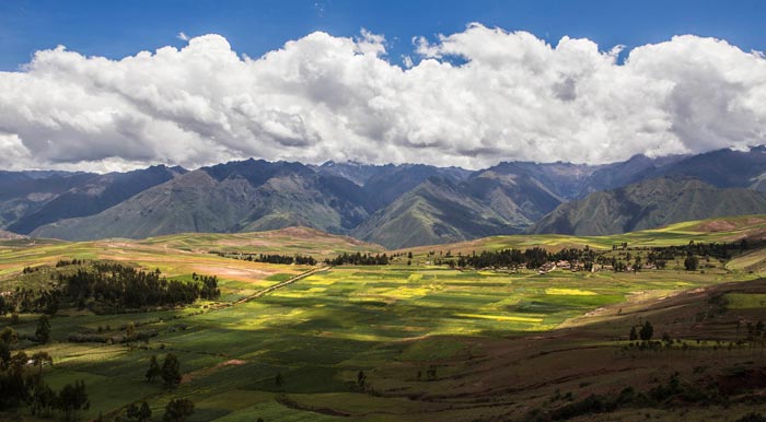 Agricultural fields surrounded by scenic mountain landscapes in the Sacred Valley of the Incas.